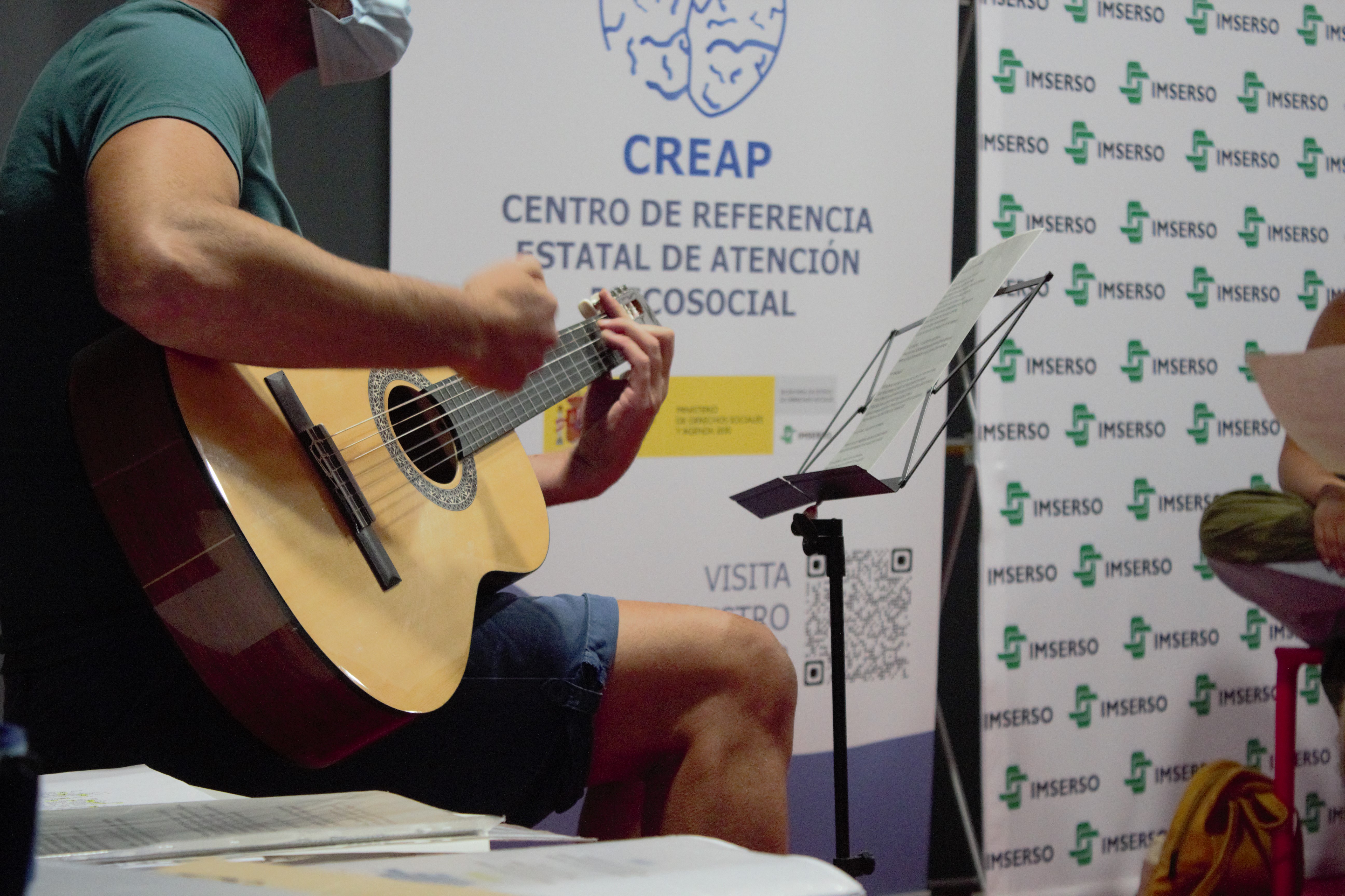 Taller de canto en el que se ve a una persona tocando la guitarra