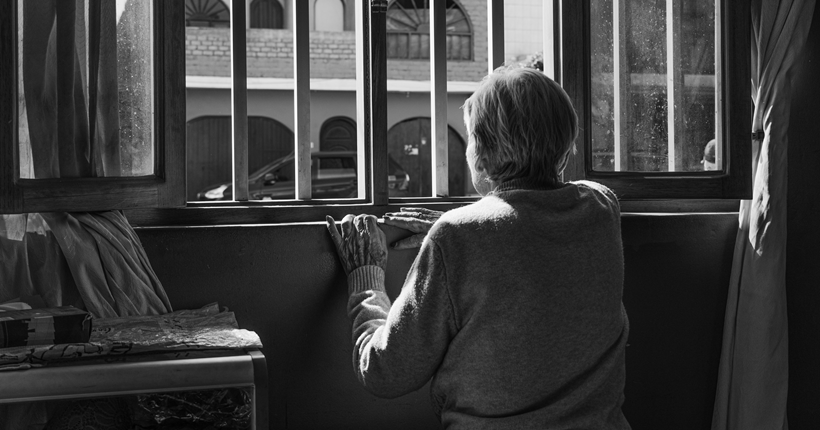 Una mujer mira por la ventana.