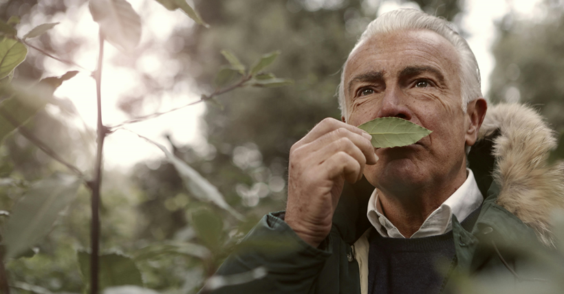 Hombre oliendo una hoja.