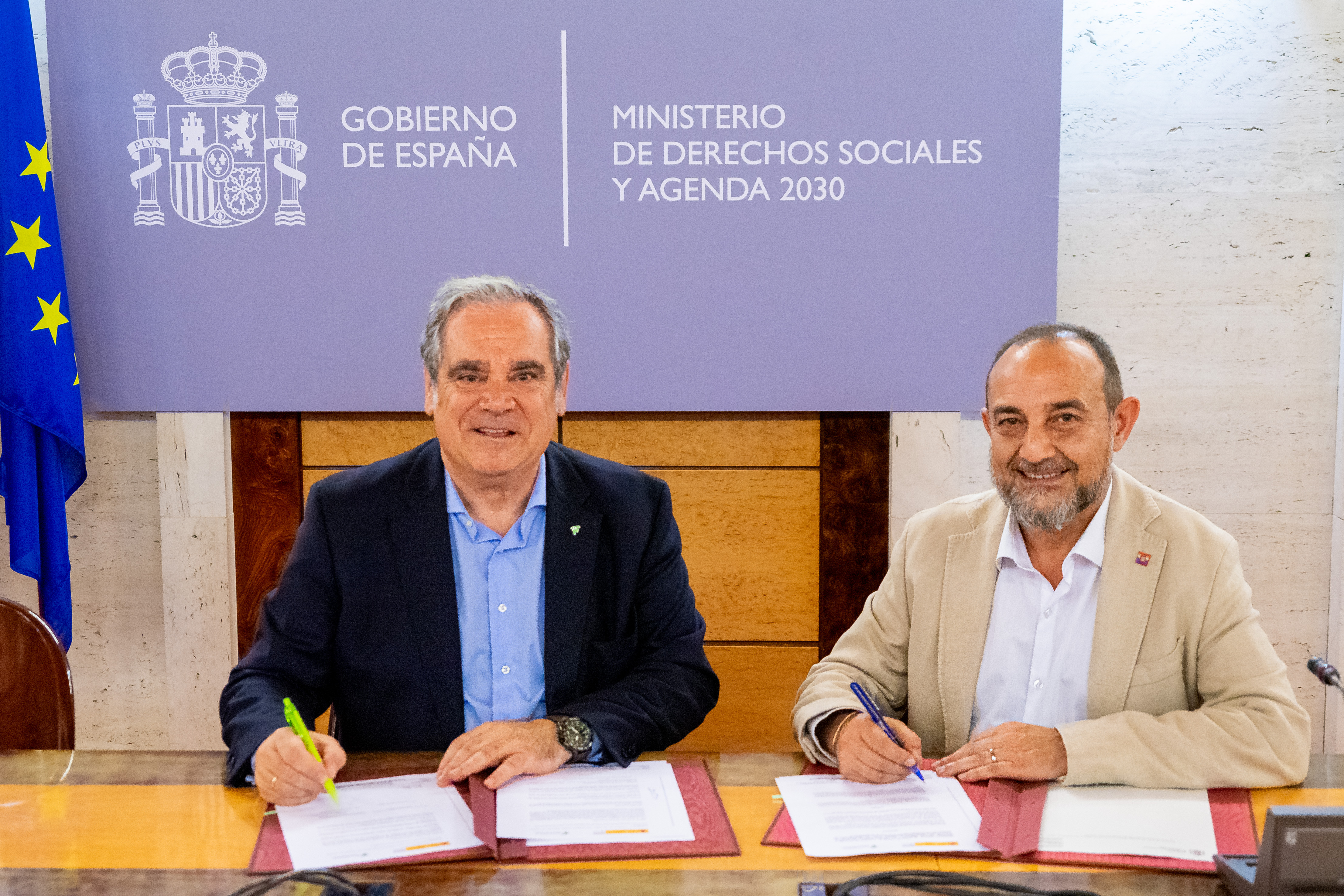 El director general del Imserso, Luis Alberto Barriga, y el presidente del Consejo General de Colegios Farmacéuticos, Jesús Aguilar firmando el Protocolo mirando a cámara.