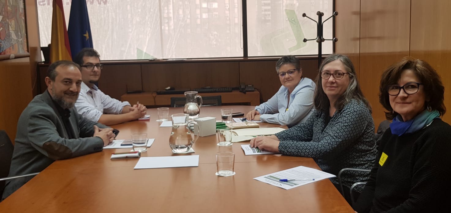 Los asistentes a la reunión sentados en la mesa