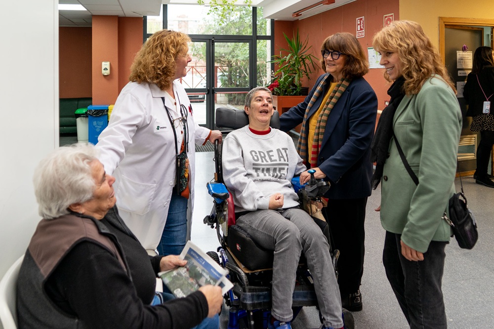 Parte de los asistentes a la visita, junto a usuarios y usuarias del centro, mientras realizan actividades.