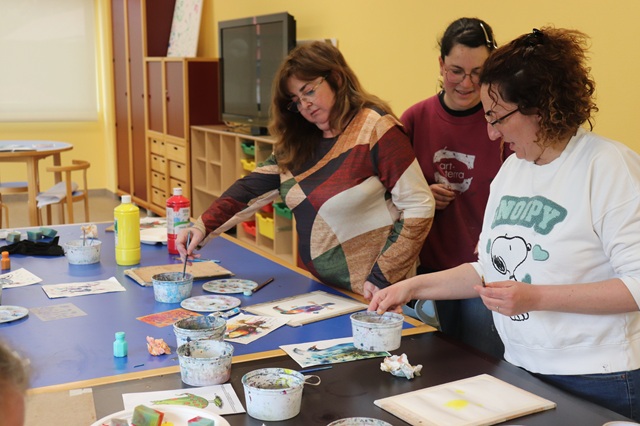 Las familias pintan con acuarelas sus creaciones.